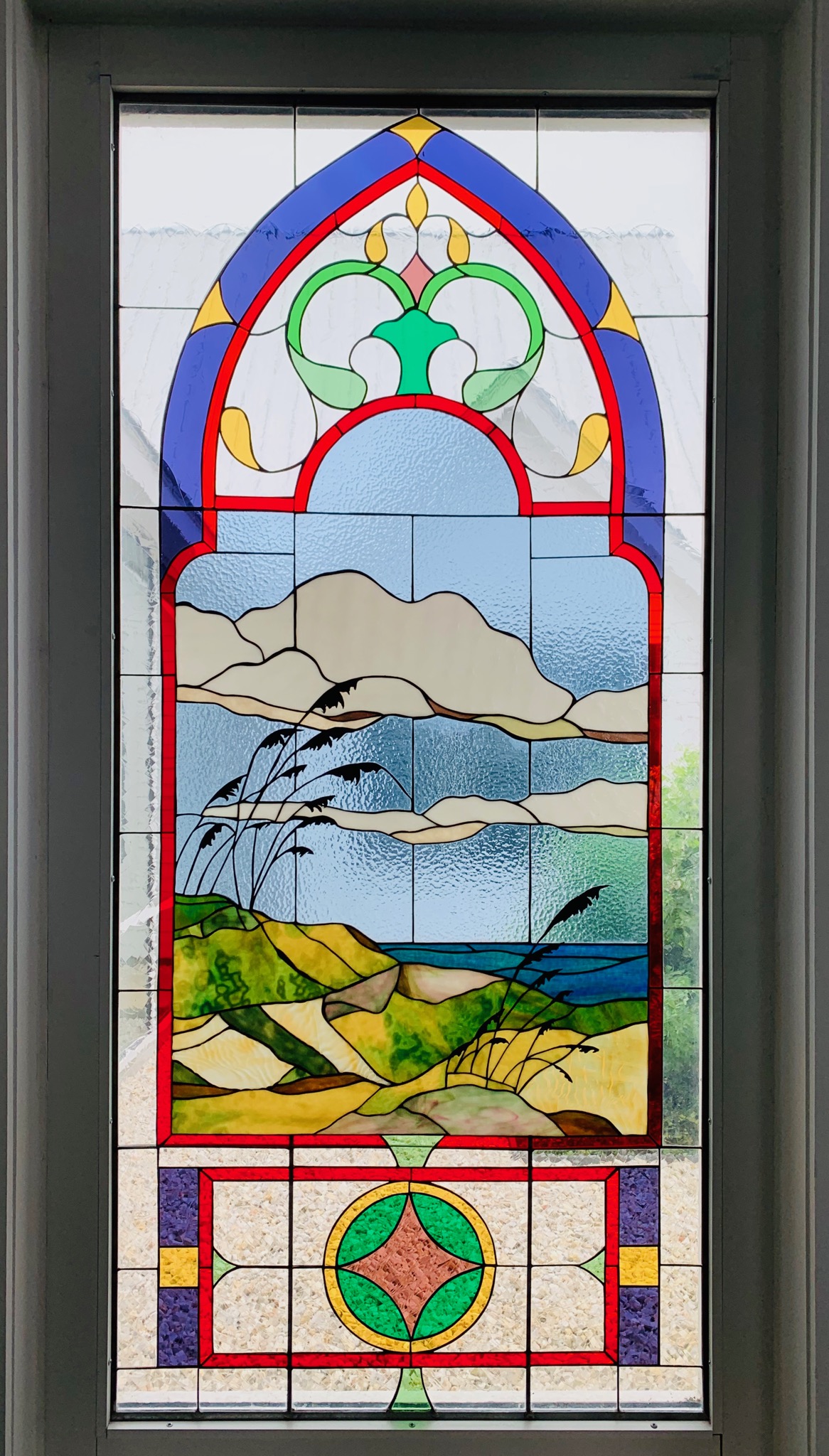 Stained glass window of
			beach